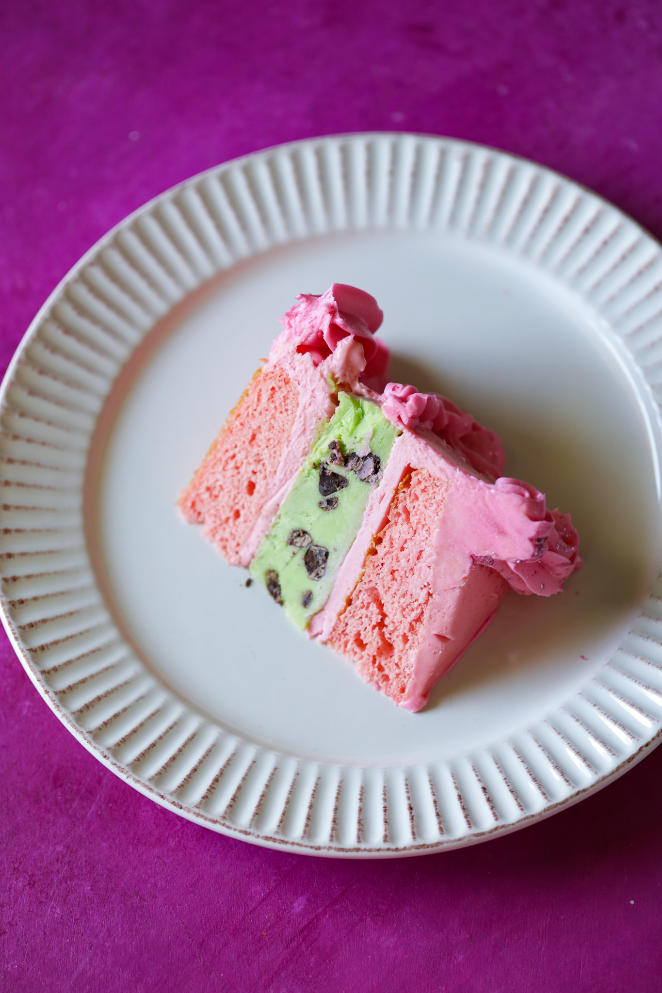 Craving a show-stopping dessert? Try this easy Vegan Strawberry Mint Chip Ice Cream Cake! Layers of creamy avocado mint chip ice cream and fluffy strawberry cake, all wrapped in luscious strawberry frosting. Perfect for parties and special occasions, plus it's freezer-friendly! #VeganDesserts #IceCreamCake #PartyRecipes #VeganCake #SummerDesserts